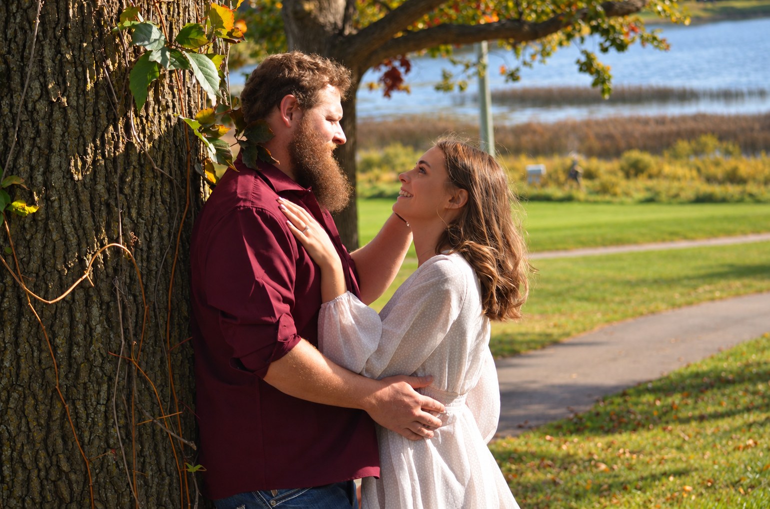 Taylor and Doug sharing a moment beside a tree in the autumn sunshine